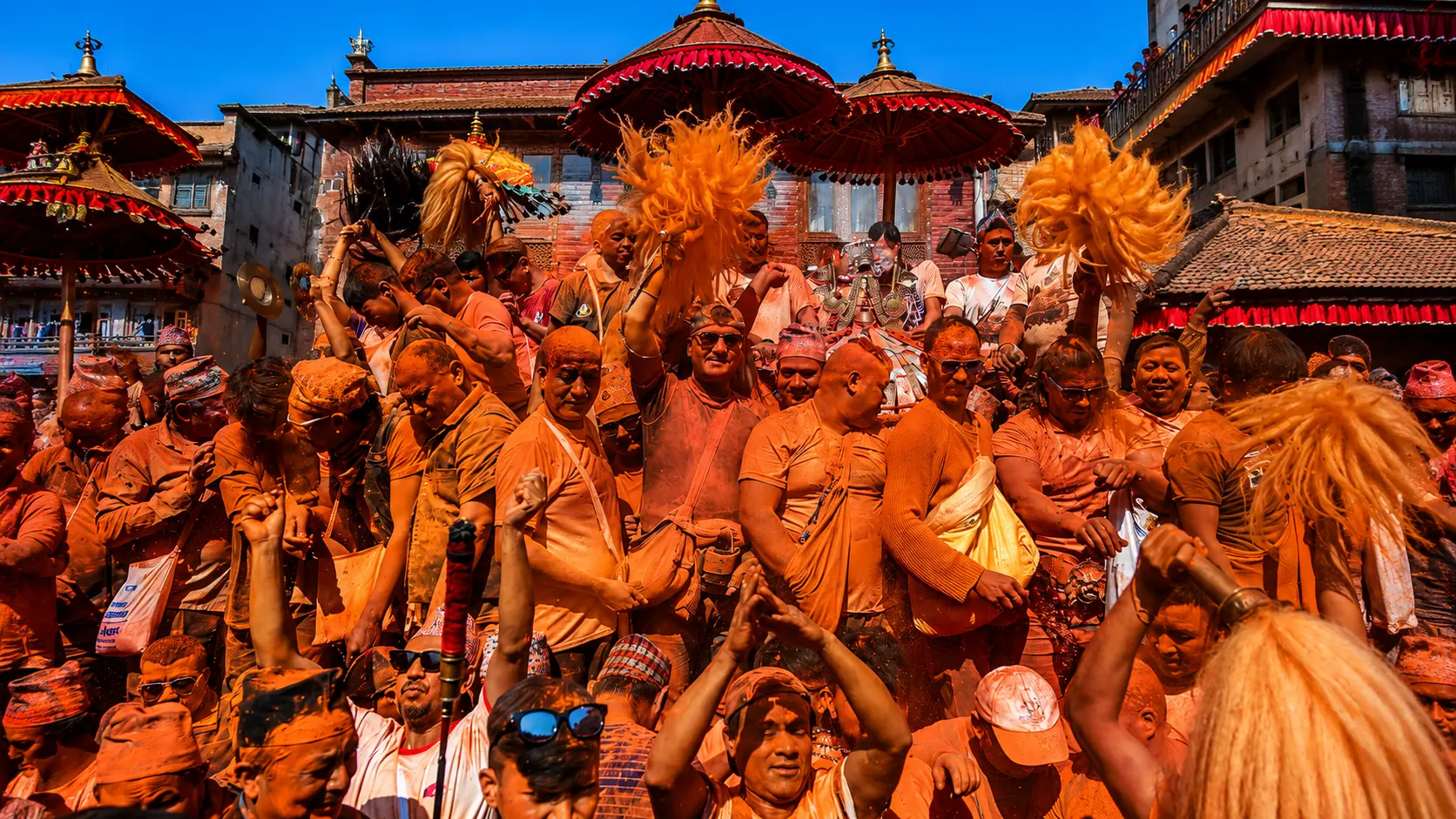 Devotees celebrating Sindure Jatra in Nuwakot, Nepal, covered in red vermilion powder during the traditional Hindu festival.