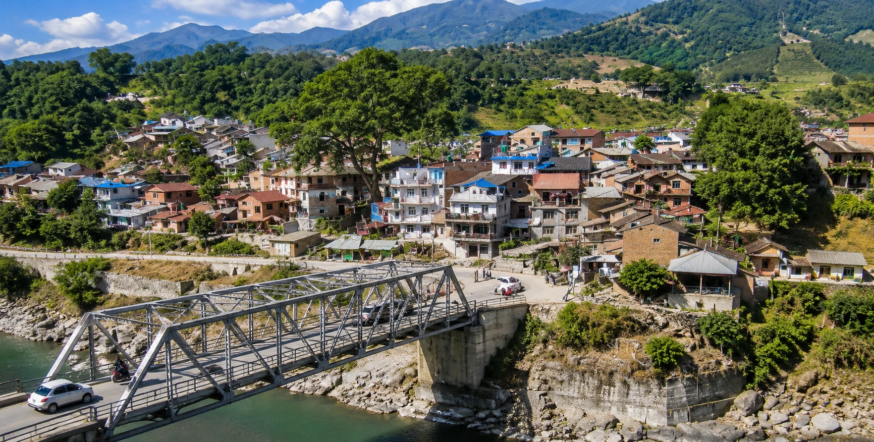 Old Trishuli Bazaar in Nuwakot, Nepal, featuring the historic market town, Trishuli River, suspension bridge, and surrounding green hills.
