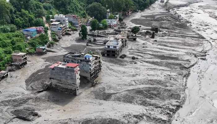 Latest Nepal flash flood condition news covering flood-affected districts, road and bridge disruptions, travel conditions, border access, and safety information for travelers and vehicle operators. Flash flood damage in Nepal with flooded roads, debris, damaged bridges, and emergency rescue operations